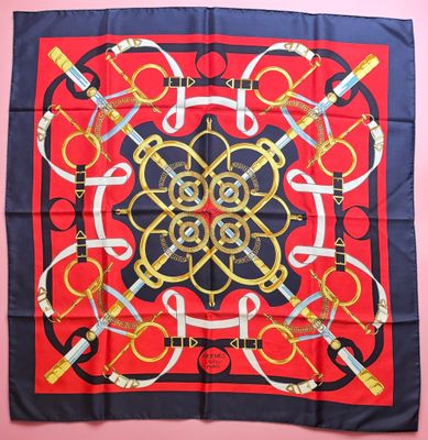 a red and blue square scarf with a gold and black design