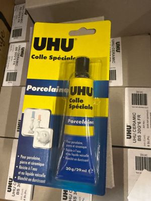 un tube de colle posé sur une boîte en carton