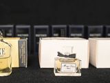 three bottles of perfume sitting on top of a table next to boxes