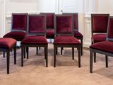 six chaises rouges disposées en cercle dans une pièce