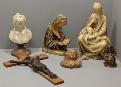 quatre statues de Jésus et une femme assise sur une croix