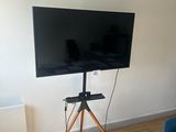 un téléviseur à écran plat posé sur un trépied dans un salon