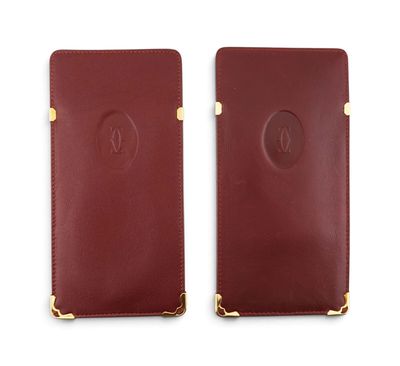 une paire de portefeuilles en cuir rouge avec des finitions dorées