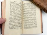 a person holding an open book on a table