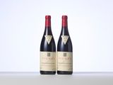 two bottles of red wine sitting on top of a table