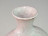 a pink vase sitting on a table with a white background
