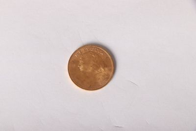 a small coin on a white surface next to a smaller coin
