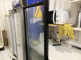 un réfrigérateur qui se trouve dans une cuisine, avec un micro-ondes posé dessus