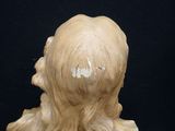 a statue of a woman with long hair on a black background