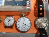 three different types of watches on display in a display case