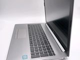 a silver laptop with a black keyboard on a white surface