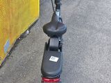 a scooter that is parked in front of a fence