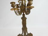 an antique brass candelabra with five candles on a stand