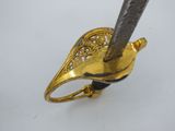 an image of a gold and silver ring with a knife sticking out of it