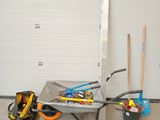 une brouette chargée d'outils devant la porte d'un garage