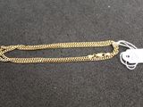 a close up of a gold chain with a tag on it
