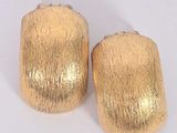 pair of gold toned metal napkin napkins on a white surface