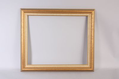 un cadre photo en or vide accroché à un mur blanc