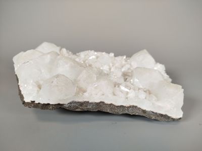 white crystals on a rock on a gray surface