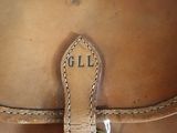 a close up of a brown leather bag with a name on it