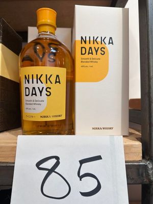 une bouteille de Nikka Days posée sur une étagère, à côté d'un livre