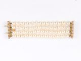 un gros plan sur un bracelet blanc orné de perles