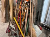 a pile of brooms and other tools in a garage