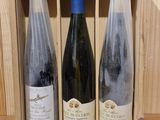 three bottles of wine in a wooden box on a table