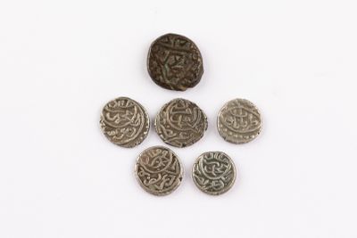 several silver coins are arranged in a circle on a white surface