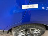 a close up of a blue car with a sticker on it