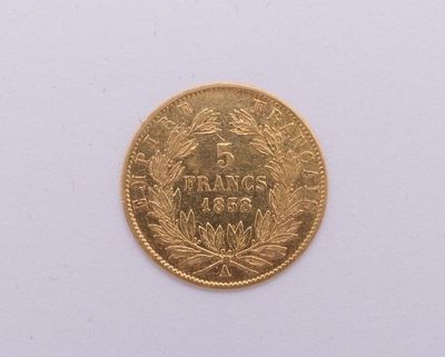 gros plan d'une pièce d'or sur une surface blanche