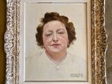 Une peinture à l'huile représentant une femme en robe blanche est accrochée au mur.