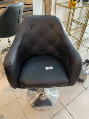 une chaise noire qui se trouve dans une pièce