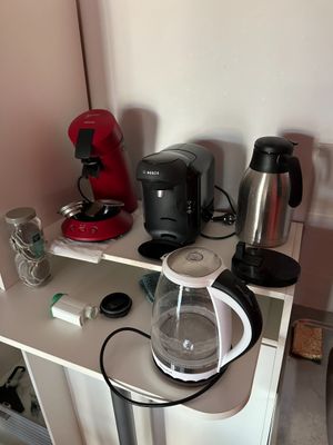 a coffee maker sitting on top of a shelf next to a coffee pot
