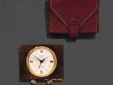 une horloge et un portefeuille posés l'un à côté de l'autre sur une table
