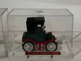 a small toy car in a clear box on a white surface