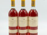 trois bouteilles de vin posées les unes à côté des autres sur une surface blanche
