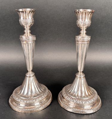 pair of antique silver candlesticks on a black background