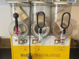 trois distributeurs de sodas posés sur un plan de travail