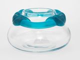 un saladier en verre transparent muni d'une poignée bleue