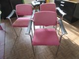 quatre chaises roses alignées dans une pièce