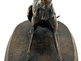 statue of a dog on a base with a ball in it ' s mouth