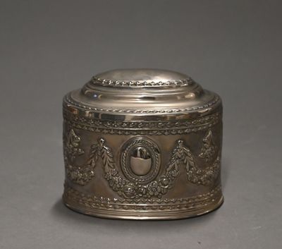 an antique silver plated box with a lid on a gray surface