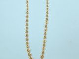 a gold necklace with a chain that has a ball design on it