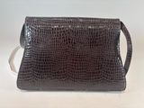 brown alligator skin purse on white background