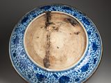 blue and white plate with floral decoration on a stand