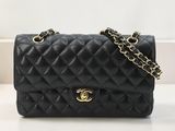 un sac Chanel noir posé sur une table blanche