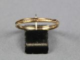 gros plan d'une bague en or sur une surface noire