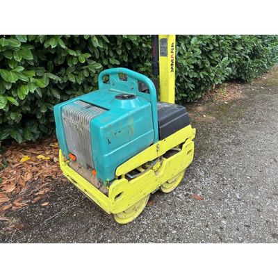 une petite machine bleue et jaune posée par terre