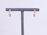 a pair of diamond earrings on a stand